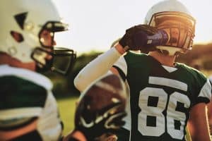 Football player drinking water during a team practice hydration homie