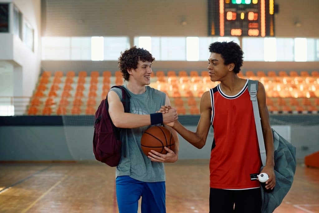 Young basketball players greeting after team sports training under CISSN coach.